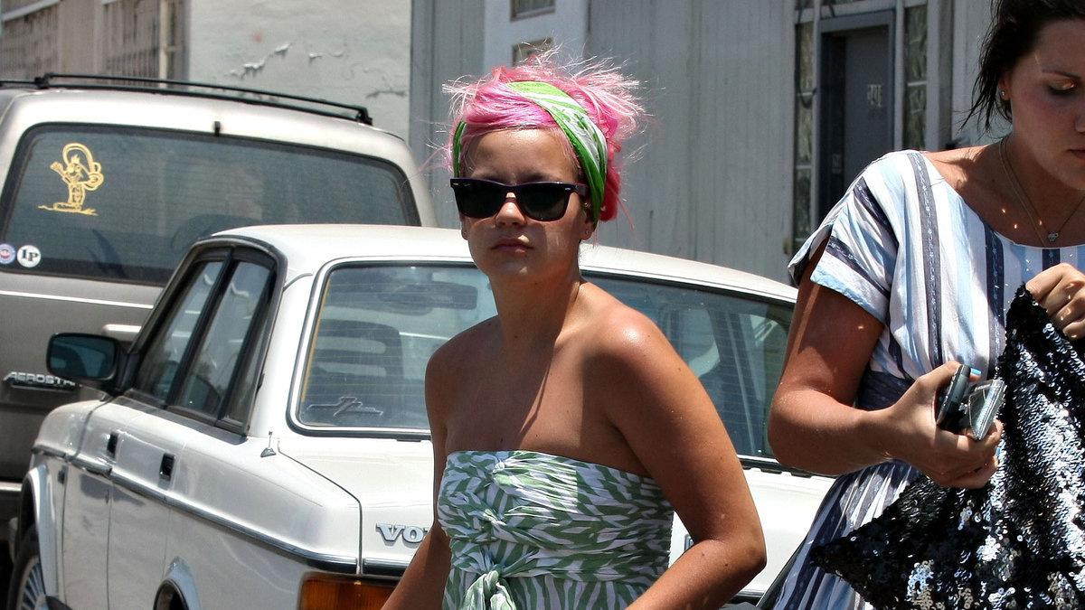 Lily Allen i rosa ruffsigt hår, grönt band i håret och en turkos/vit klänning. När det är varmt finns det inget bättre att ha på sig än detta...