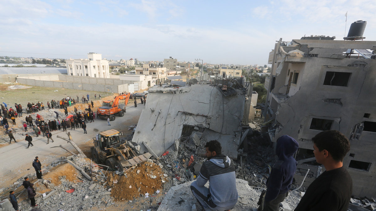 Palestinier ser på förödelsen efter en israelisk attack på ett bostadshus i Rafah den 16 februari.