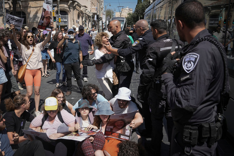 Polis skingrar demonstranter som blockerar en väg under protesterna i Jerusalem.