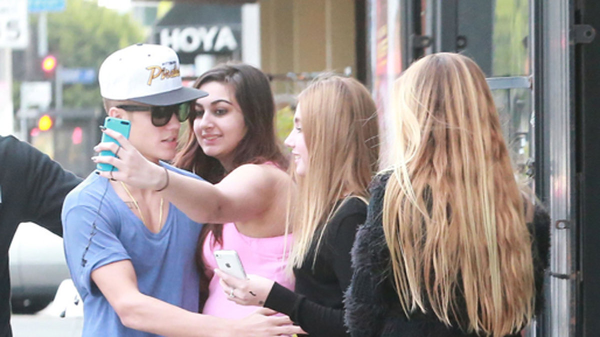 Justin Bieber kramar om ett fan som vill ta en bild.