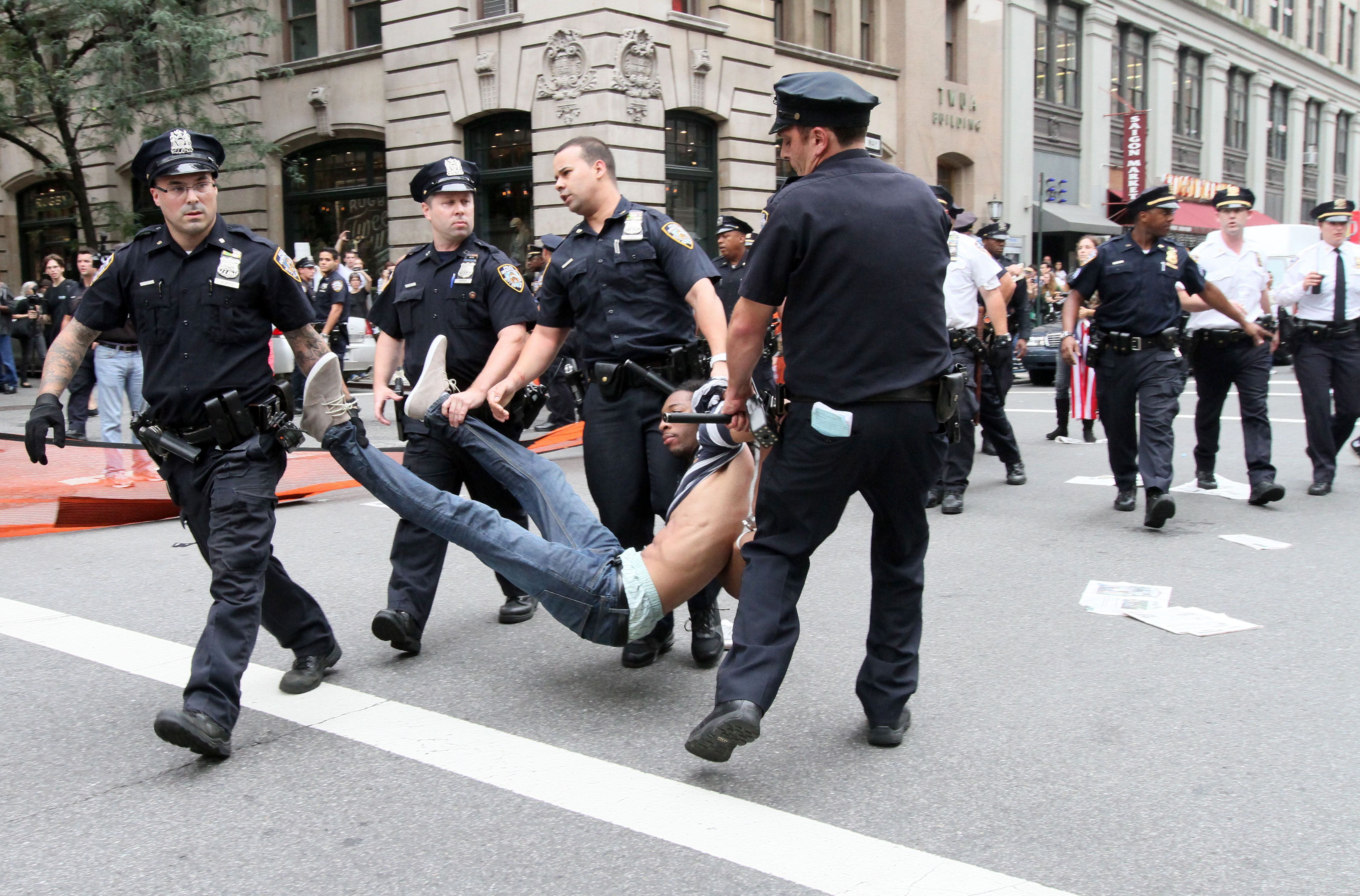 En av demonstranterna bärs bort av polisen som grep in mot en marsch på lördagen.