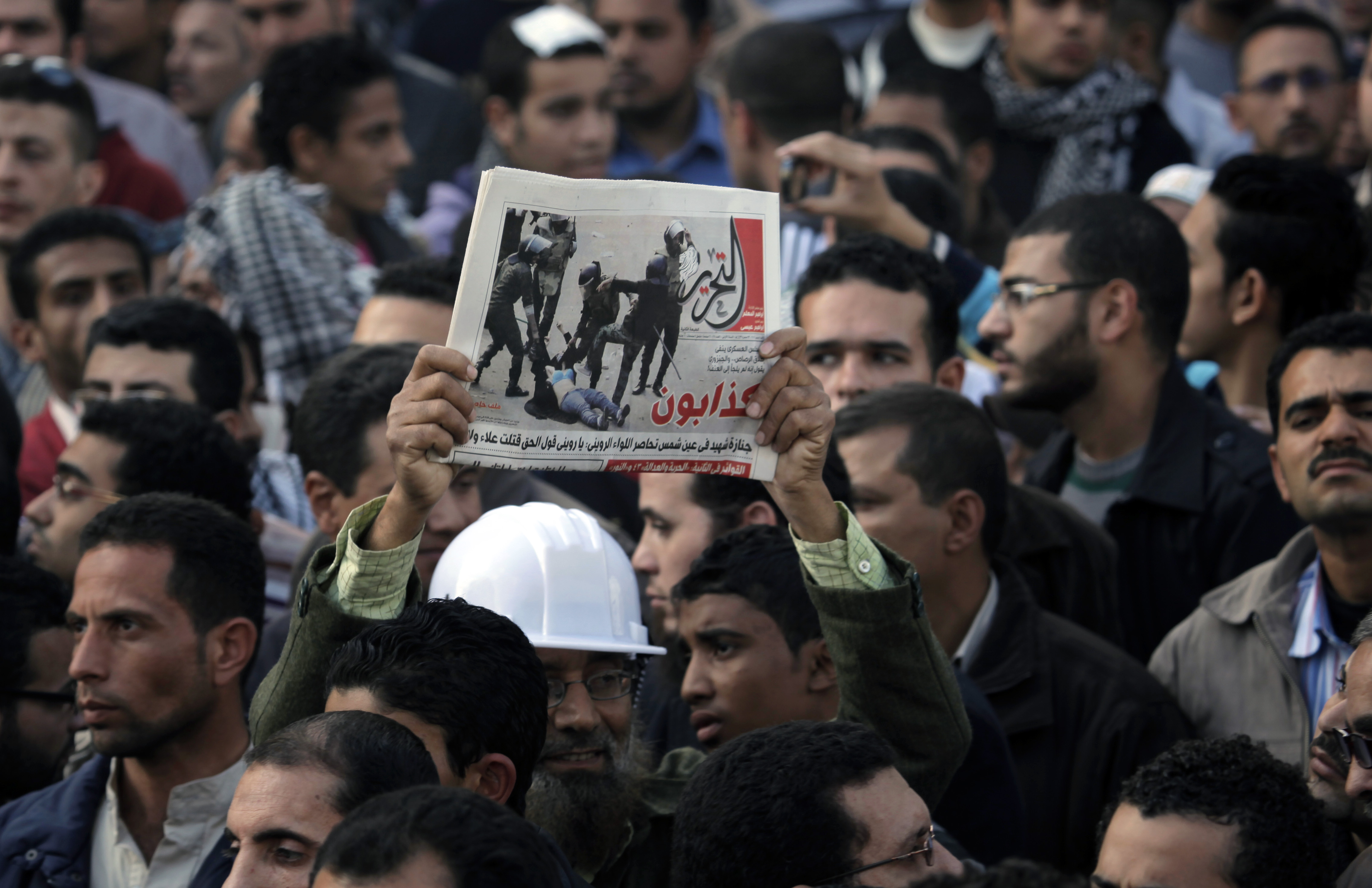 Protester i Kairo där demonstranter håller upp en bild från det omtalade videoklipp där en kvinna blir stampad på av militären.