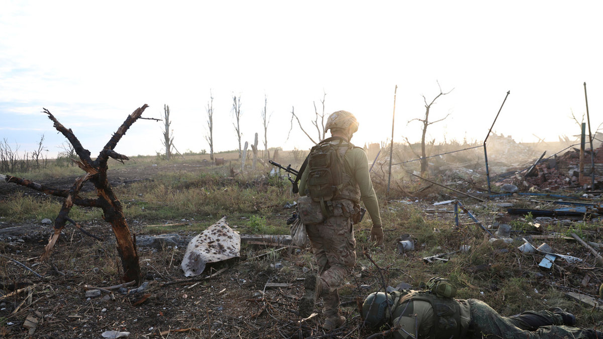 En ukrainsk soldat går förbi kvarlevorna av en rysk soldat vid frontlinjen i Andrijivka, en ort i Donetsk som Ukraina tog kontroll över i september. Arkivbild från den 16 september.