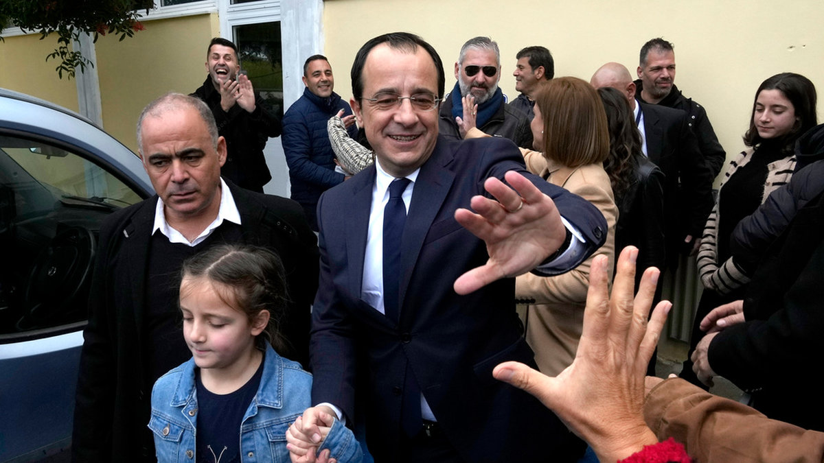 Cyperns förre utrikesminister Nikos Christodoulides hälsar på väljare utanför sin vallokal på söndagen.