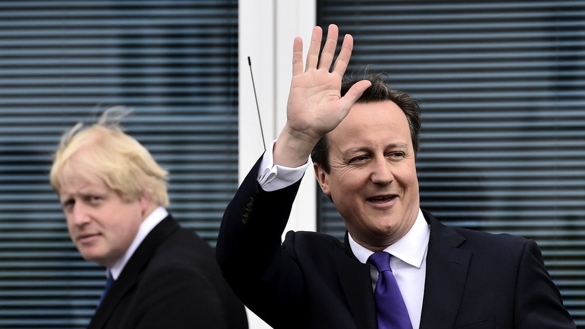 Storbritanniens dåvarande premiärminister David Cameron - med sedermera efterträdaren Boris Johnson i bakgrunden - efter ett valmöte 2015. Arkivfoto.