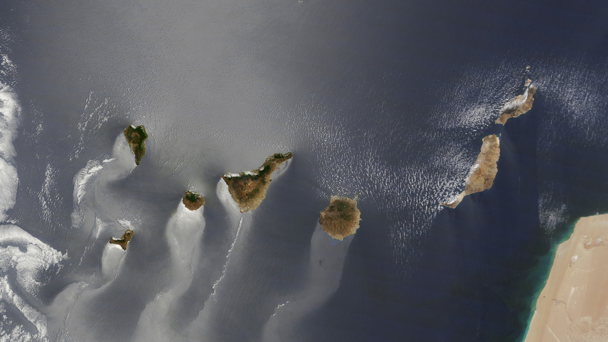 Denna bild visar kanarieöarna. Soljuset reflekteras i vattnet kring öarna. 