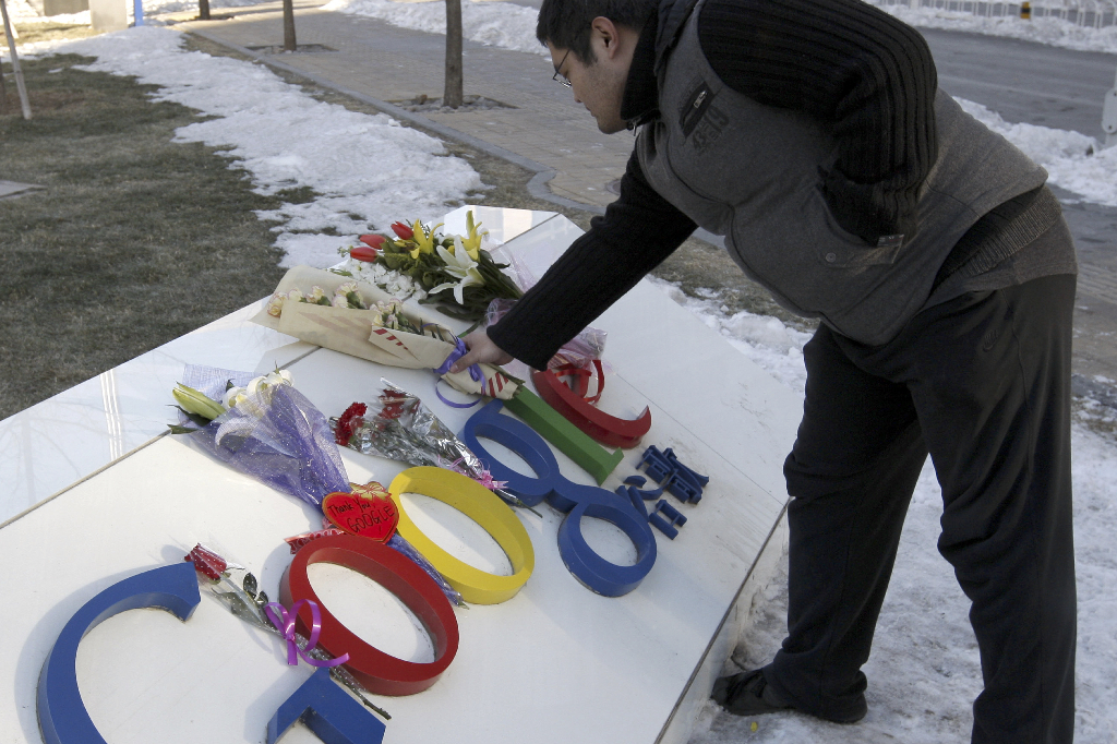 En man lägger blommor vid Googles kontor i Peking efter företagets beslut att sluta censurera sökresultat i Kina.