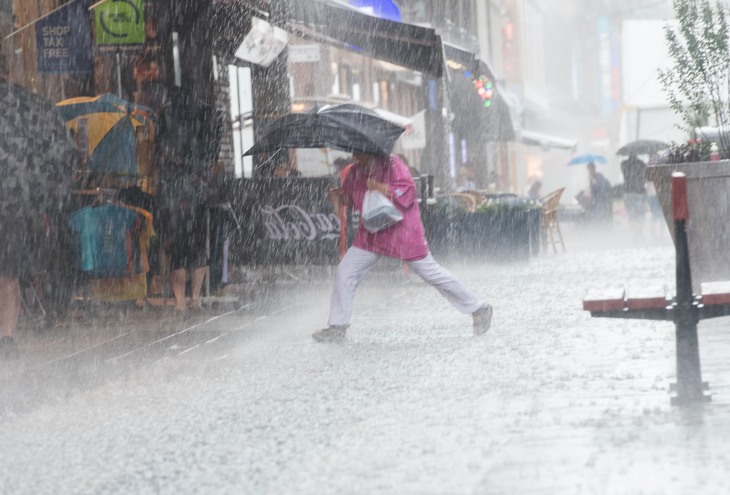 Kvinna springer genom regn Kvinna springer genom regn