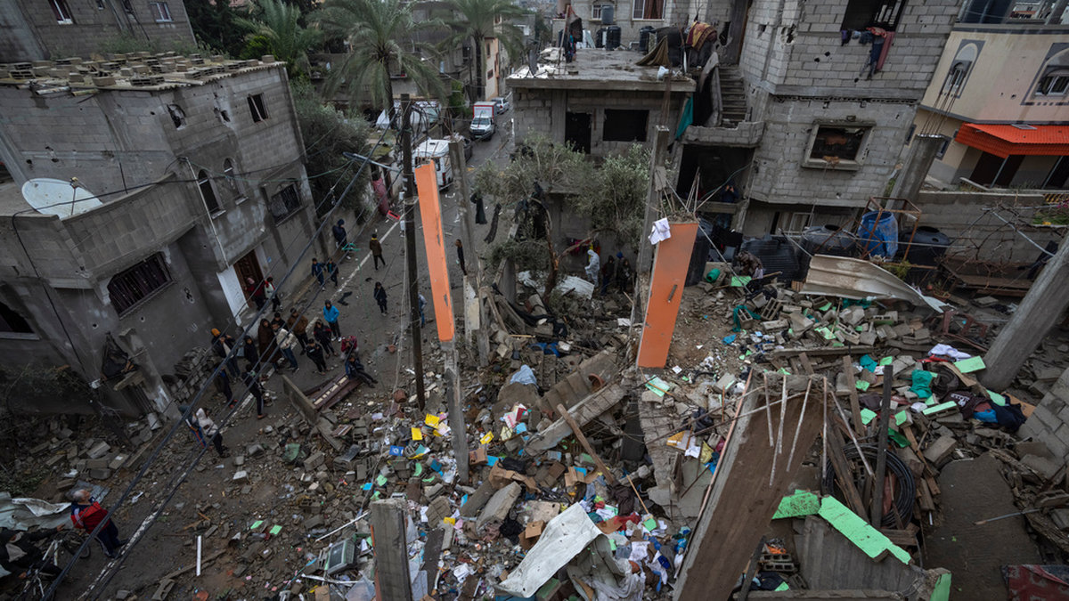 Människor samlade vid förstörda byggnader i Rafah i södra Gaza.