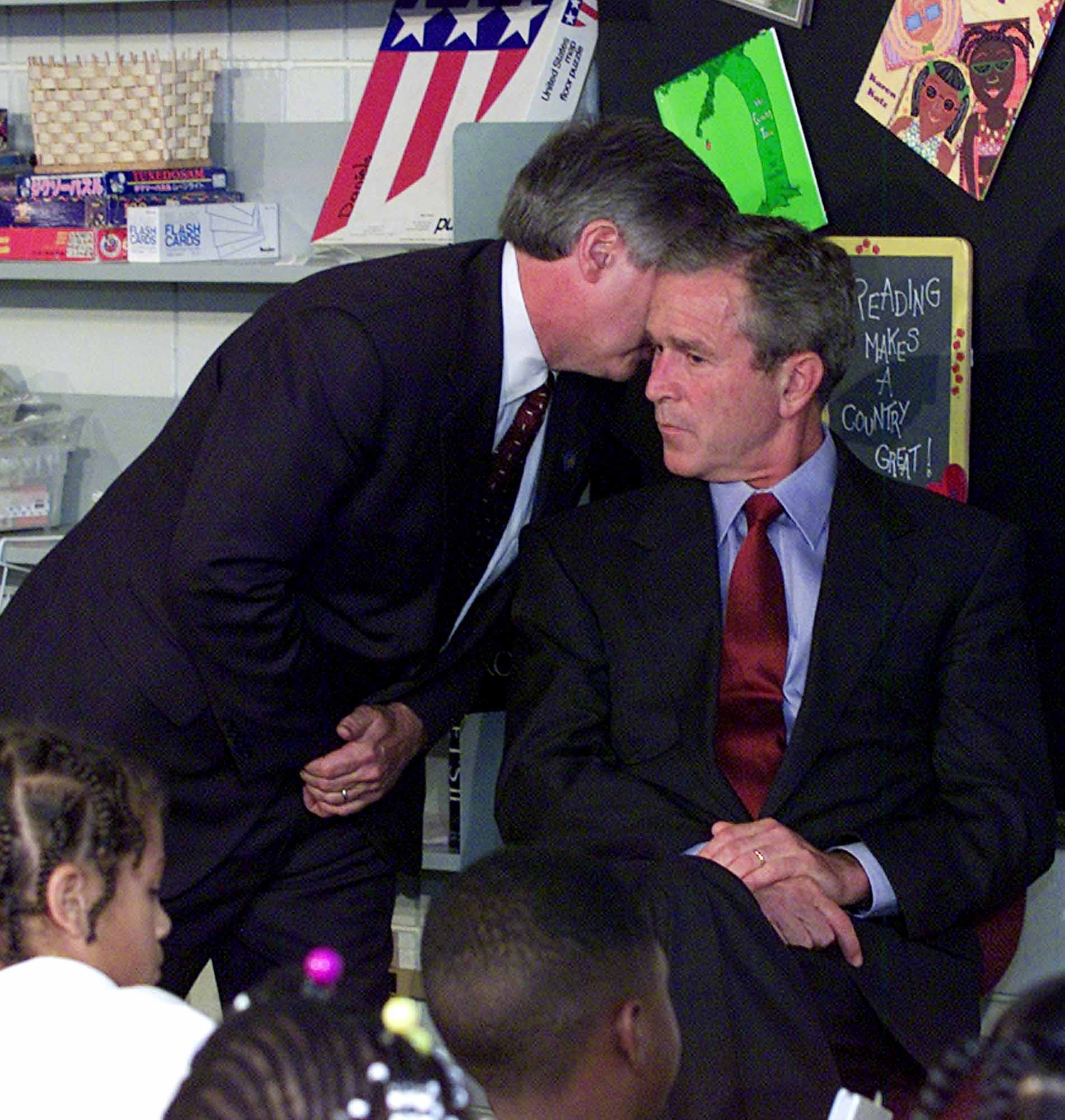 Andy Card, stabbchefe, meddelar president Gorge W. Bush kort efter det inträffade om de två kapade planen som flugits in i World Trade Center tornen. Presidenten befann sig då på grundskolan Emma E. Booker. 
FOTO: Doug Mills / SCANPIX