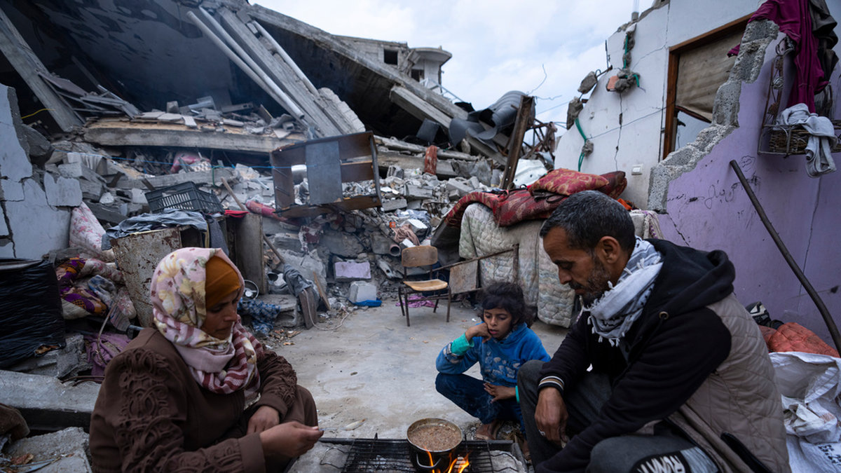 Familjen al-Rabaya bryter fastan vid solnedgången utanför deras totalförstörda hem i Rafah. Bilden är tagen den 18 mars.