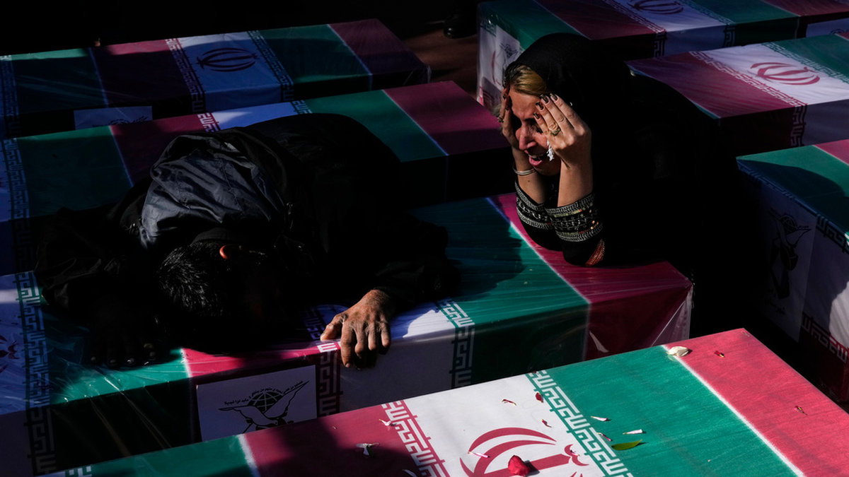 Sörjande vid en kista draperad med en flagga efter explosionen i onsdags, under en ceremoni i staden Kerman under fredagen.