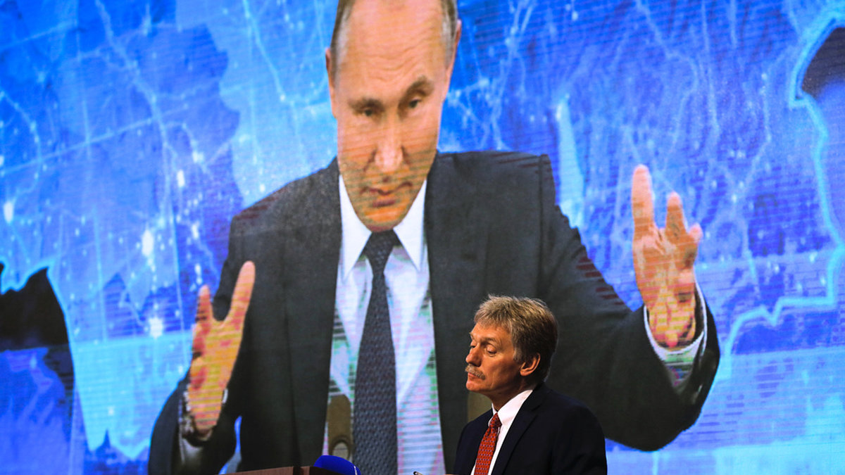 Kremls talesperson Dmitrij Peskov tittar på medan president Vladimir Putin talar via länk under en pressträff. Arkivbild.