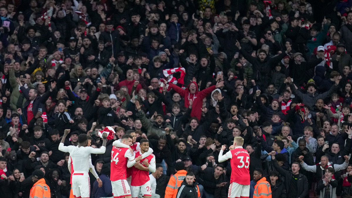 Arsenals spelare och supportrar firar segermålet mot Bournemouth i den 97:e minuten.