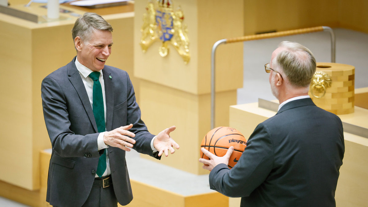 Miljöpartiets språkrör Per Bolund tackas av och får present (en basketboll) av Liberalernas partiledare Johan Pehrson.