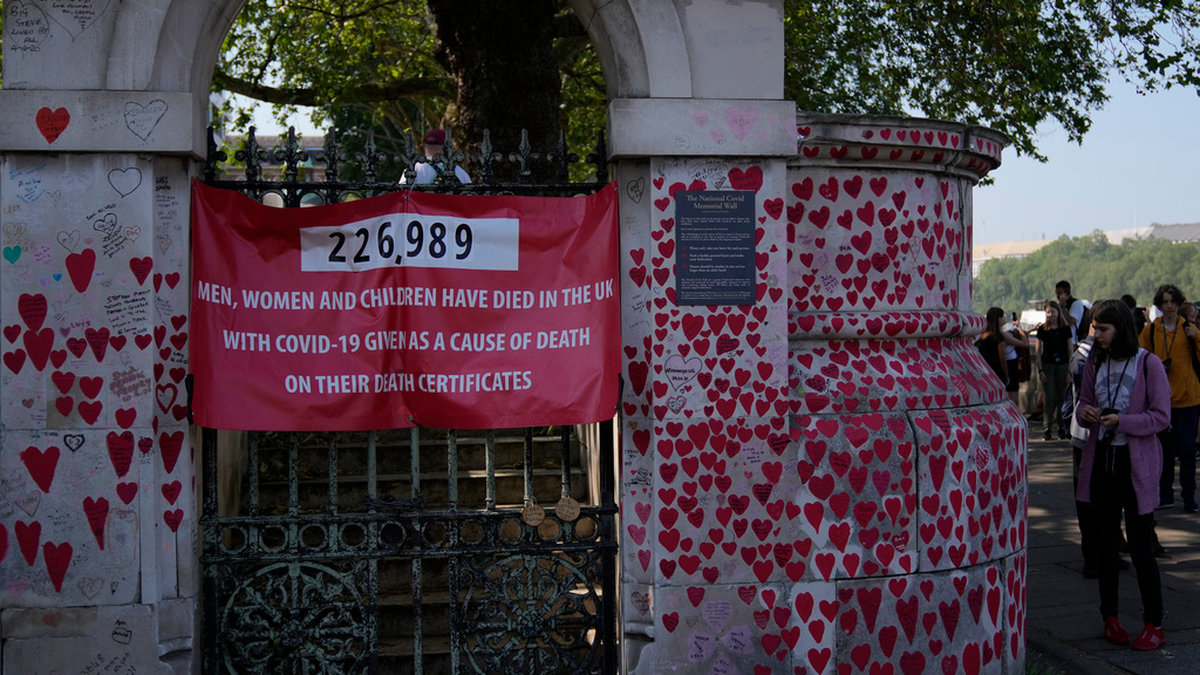 Turister går förbi minnesmonumentet 'The National Covid Memorial Wall' i London, som är tillägnat de britter som dog under coronapandemin.