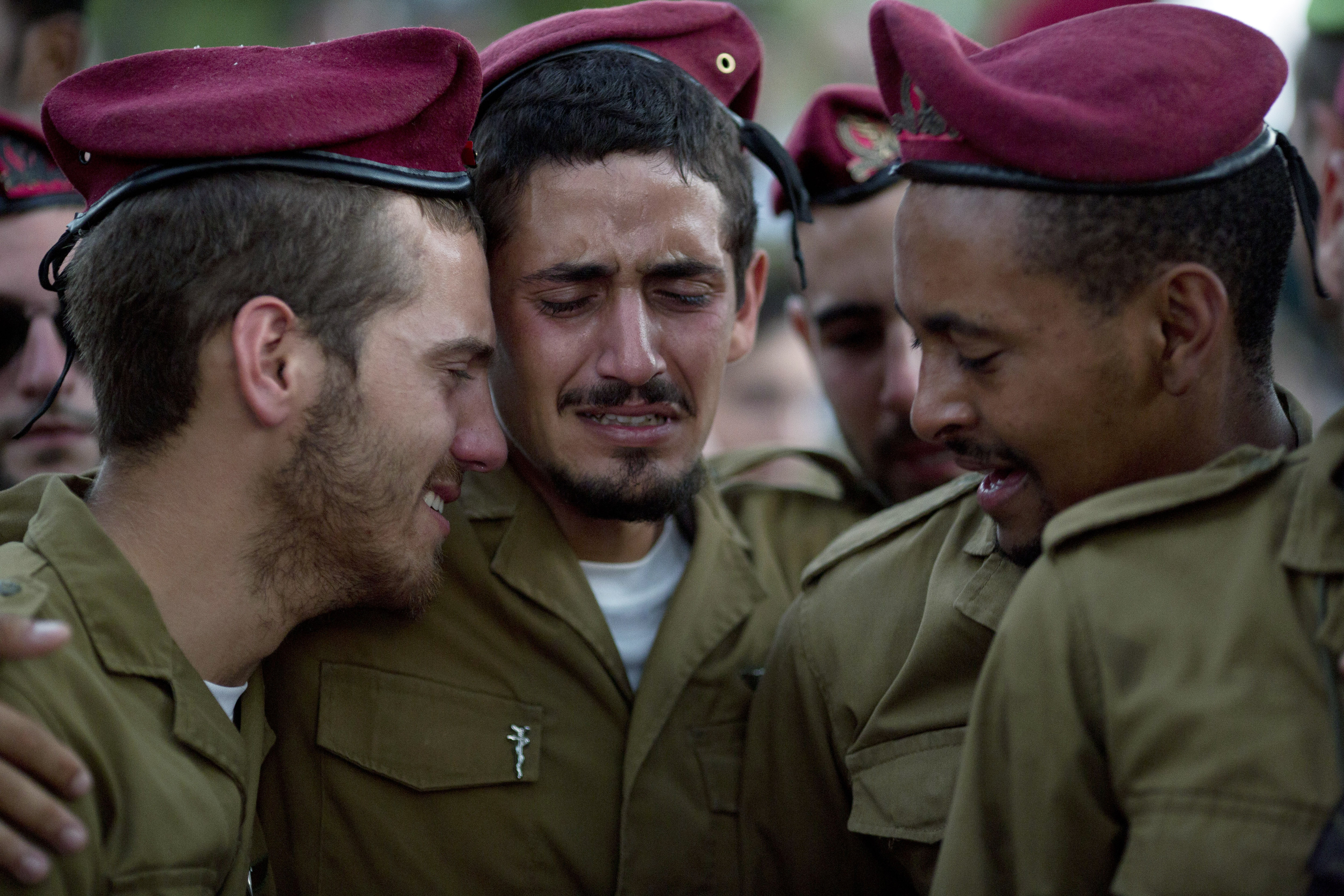 Israeliska soldater gråter på en begravning. 