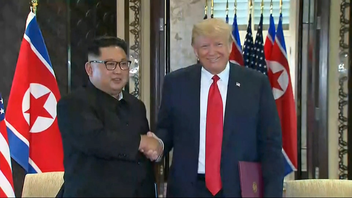 De båda männen skakar hand efter att ha skrivit på avtalet.