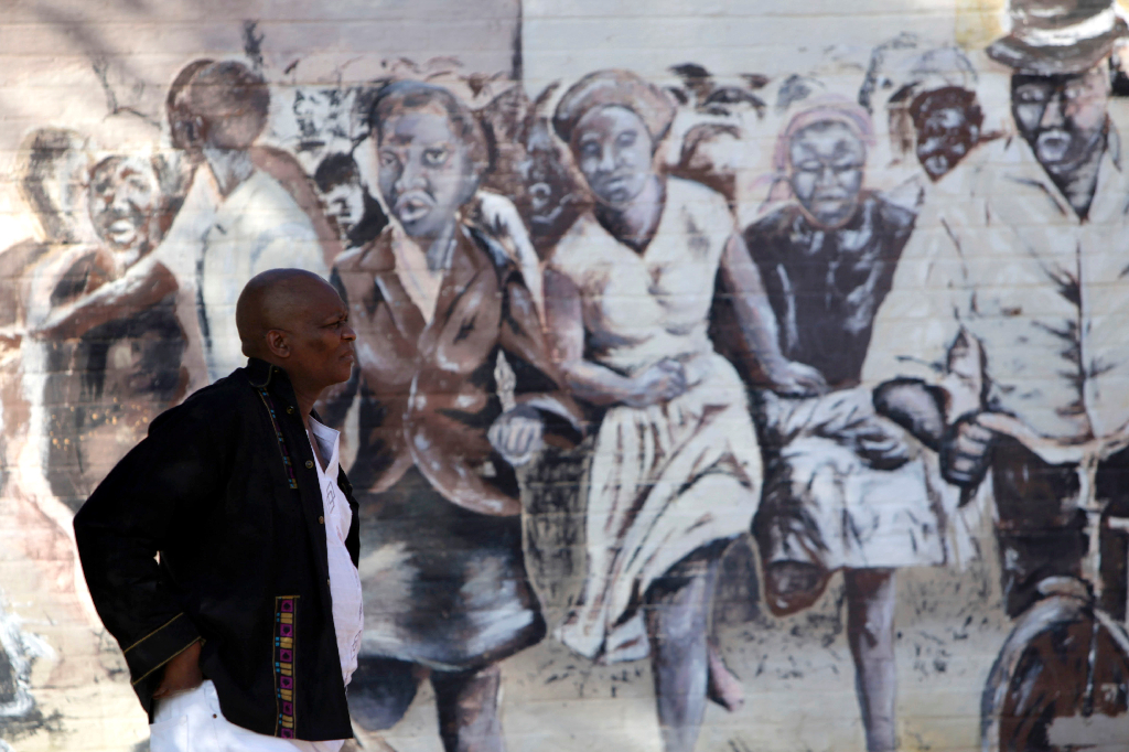 Sharpevillemassakern ägde rum den 21 mars 1960 i det svarta bostadsområdet Sharpeville strax utanför staden Vereeniging i Transvaal i Sydafrika. Här passerar en man en målning av massakern.