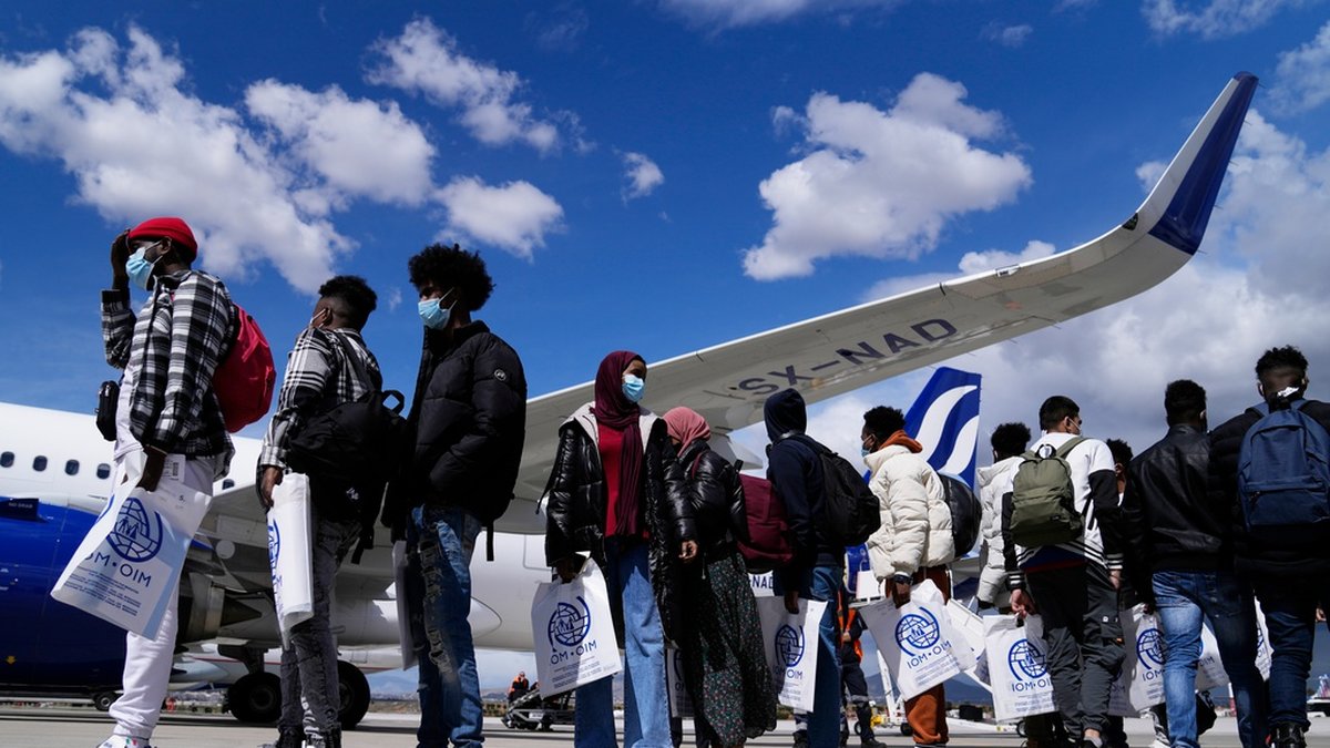 En grupp ensamkommande minderåriga köar väntar i Aten på att flyga till Lissabon inom ramen för ett omfördelningsprogram inom EU.