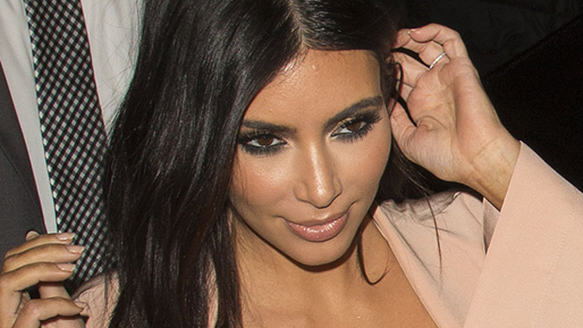 Kim Kardashian klär sig i laxrosa. 