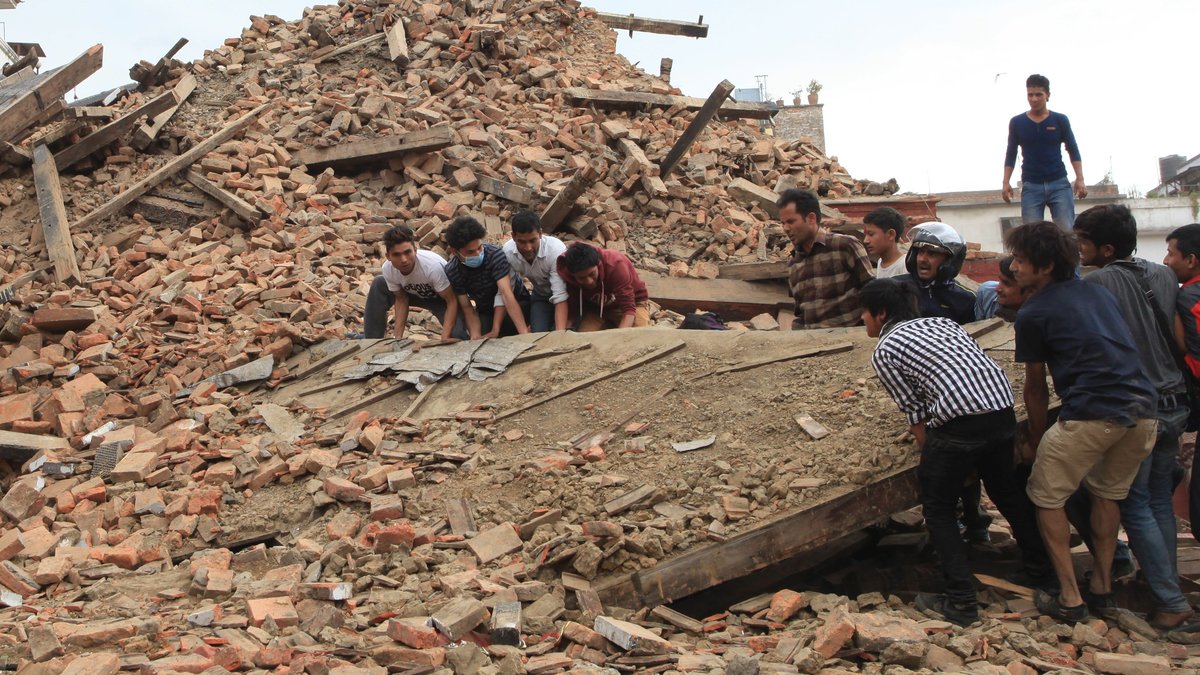 Folk försöker lyfta spillror från ett tempel på Hanumandhoka Durbar Square efter gårdagens jordbävning utanför Kathmandu.