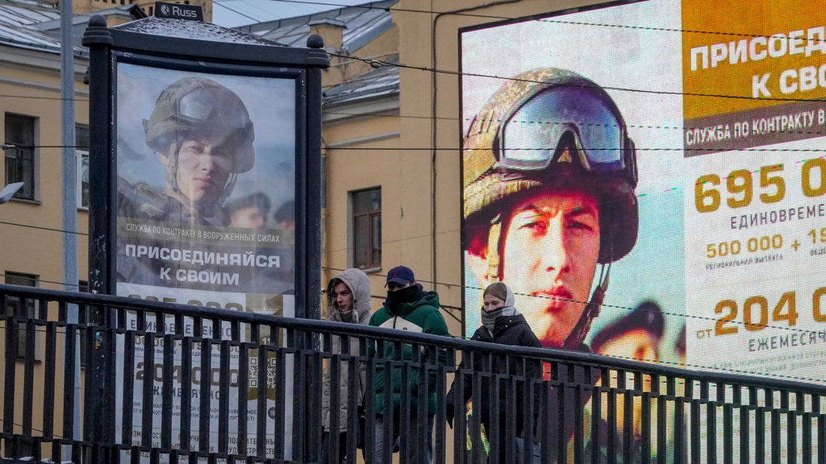 Några unga personer i S:t Petersburg promenerar förbi reklamtavlor där de uppmanas ta värvning i armén. Bilden togs den 22 november.