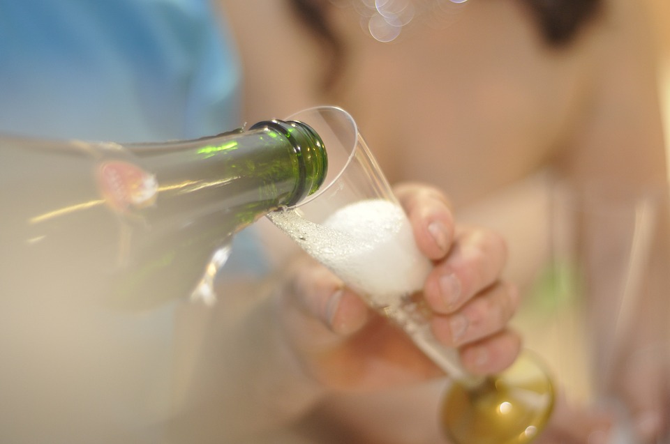 Häller upp champagne i glas Häller upp champagne i glas