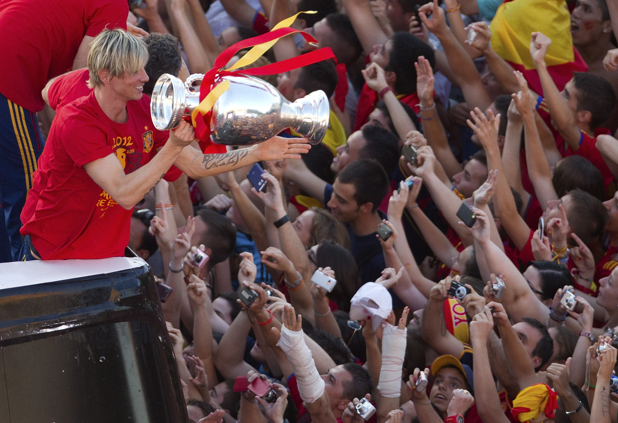 Fernando Torres, som nätade i finalen mot Italien, håller ut pokalen mot fansen.