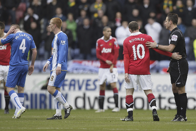 James McCarthy (t.v.) tar sig för huvudet efter armbågen från Rooney.