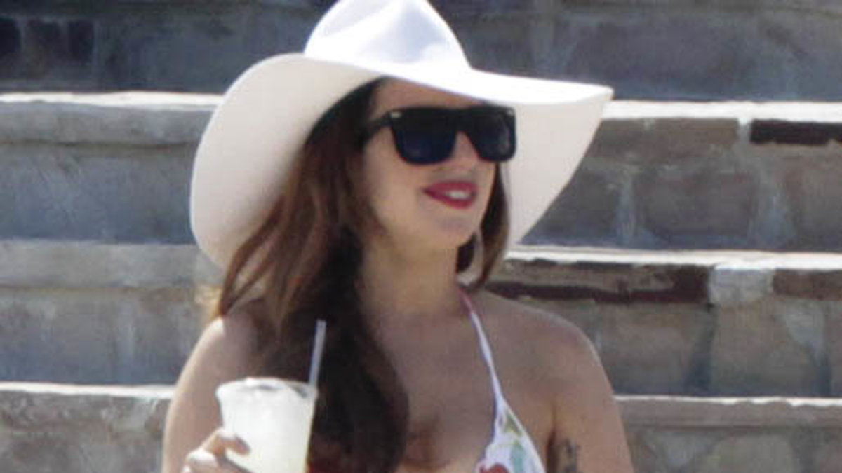 En leende Gaga i solhatt. 