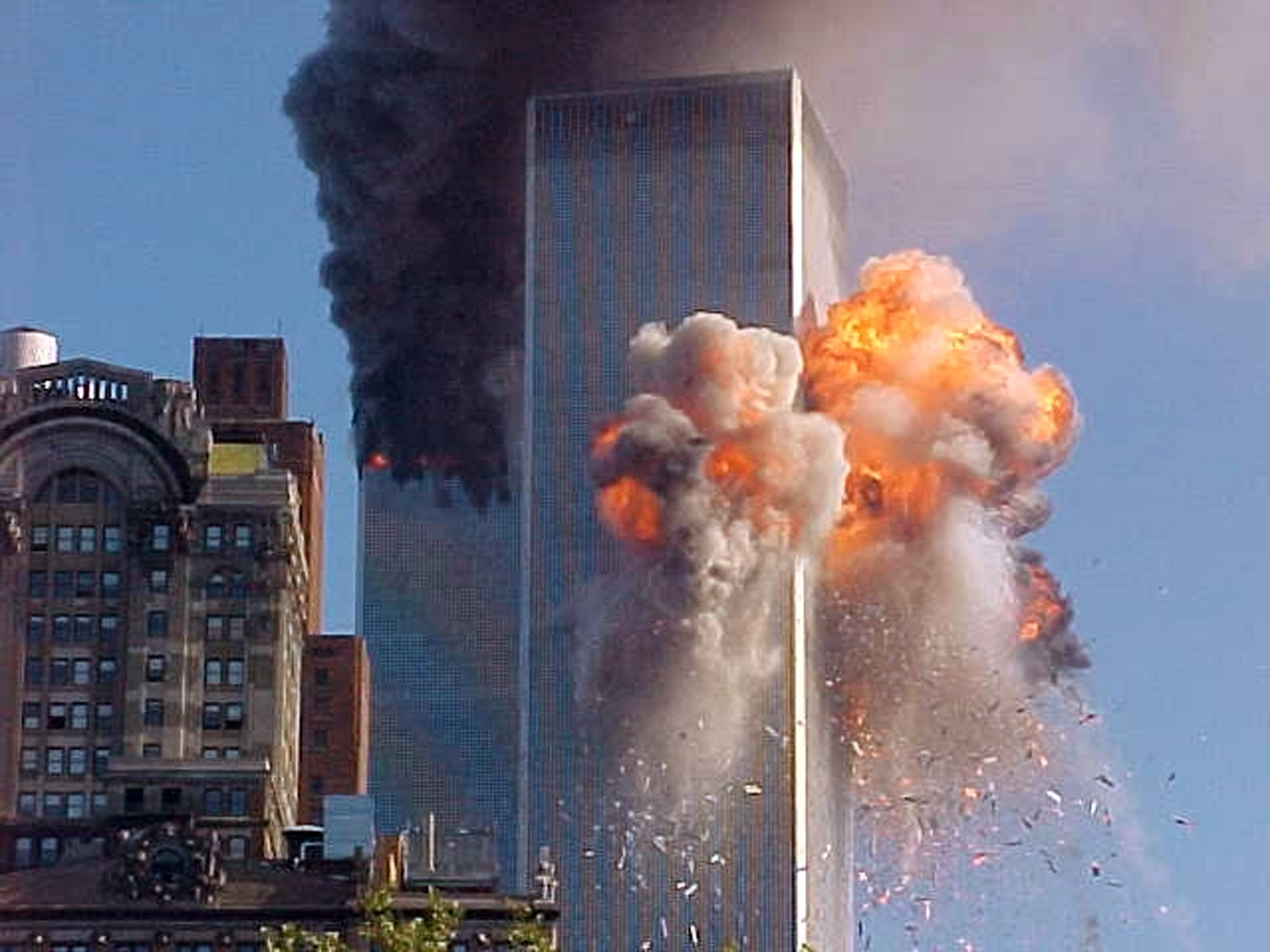 Eldklot slungas ut från det ena av de två tvillingtornen, World Trade Center, efter att ett kapat flygplan flugit in i byggnaden. 
FOTO: Carmen Taylor / SCANPIX