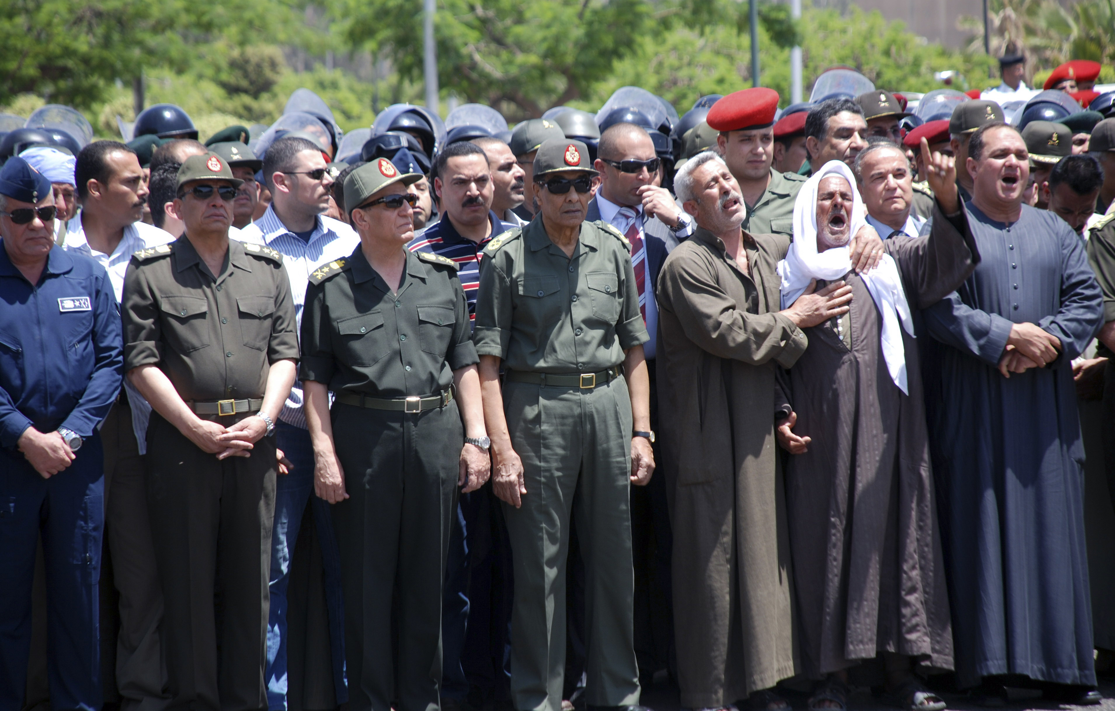 Militärrådet och dess ledare Hussein Tantawi (mitten) har infört utegångsförbud i staden efter de blodiga protesterna.
