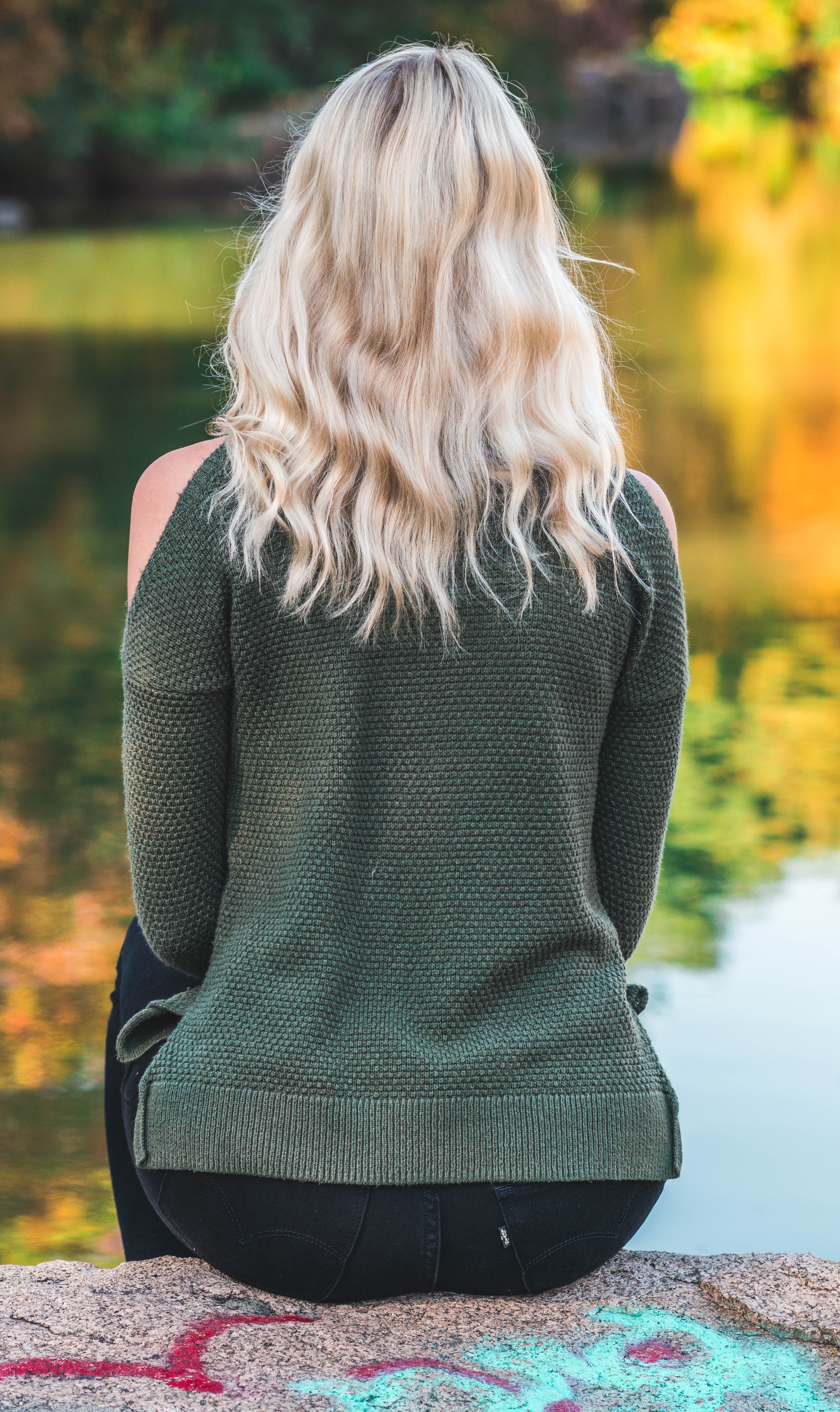 Blond tjej sitter vid vattnet Blond tjej sitter vid vattnet