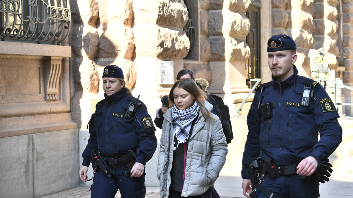 Greta Thunberg förs bort av polis vid en klimataktion utanför riksdagen på tisdagen.