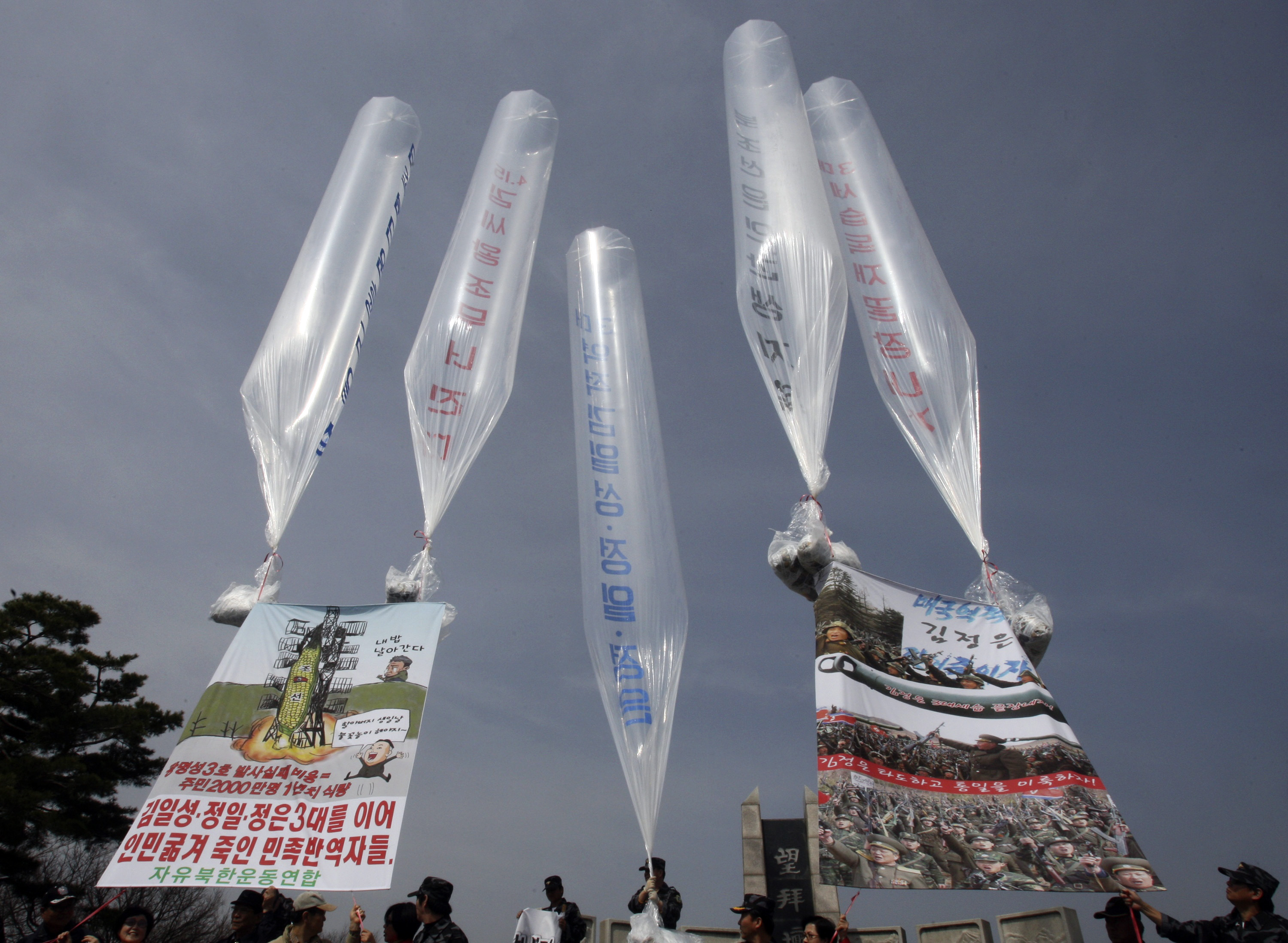 "Kim Il Sung, Jong Il och Jong Un - förrädarna som har svält folket till döds under tre generationer", står det på skylten till vänster.