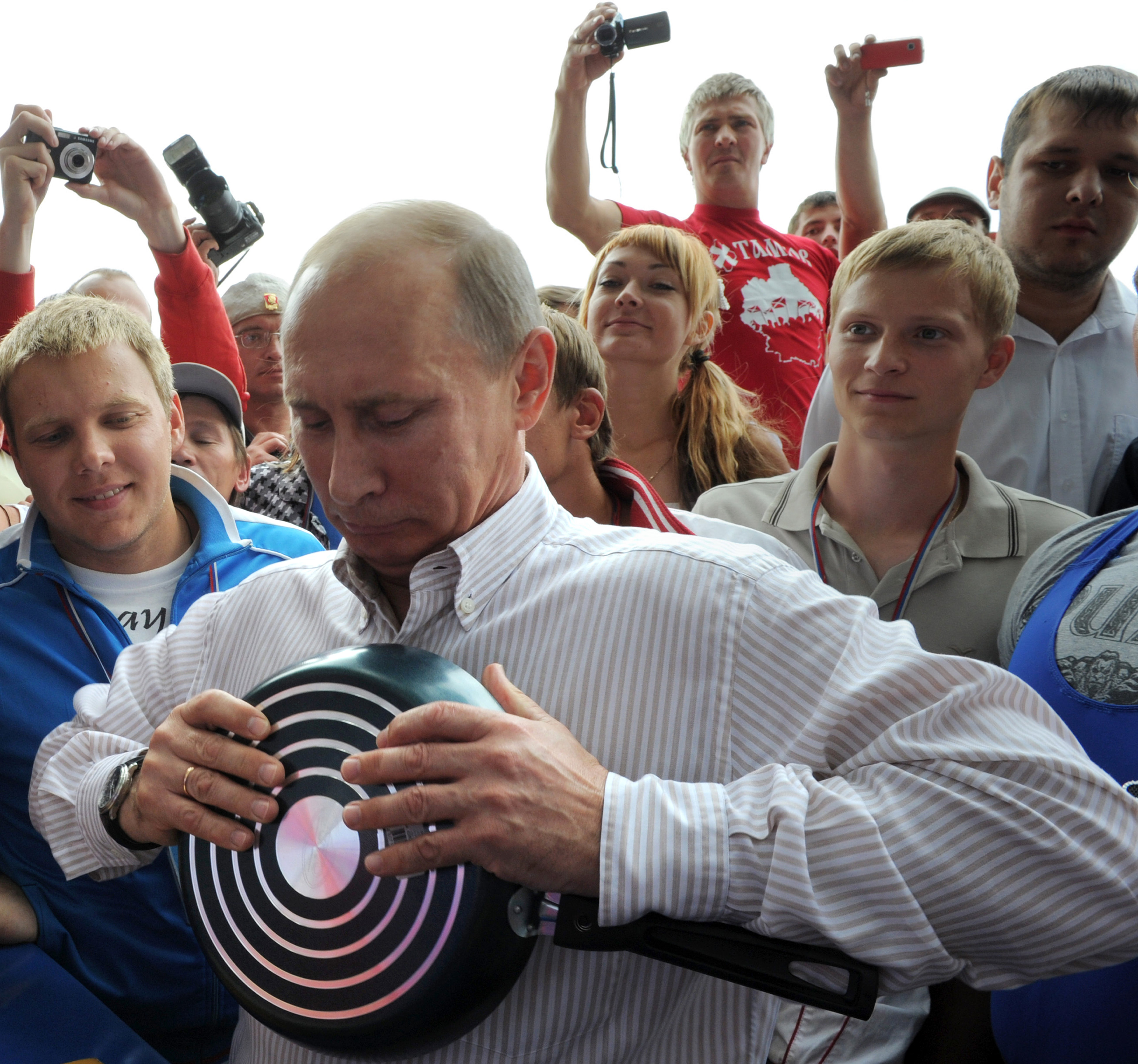 59-årige Vladimir Putin poserar framför kameran samtidigt som han försöker böja en titankastrull.
