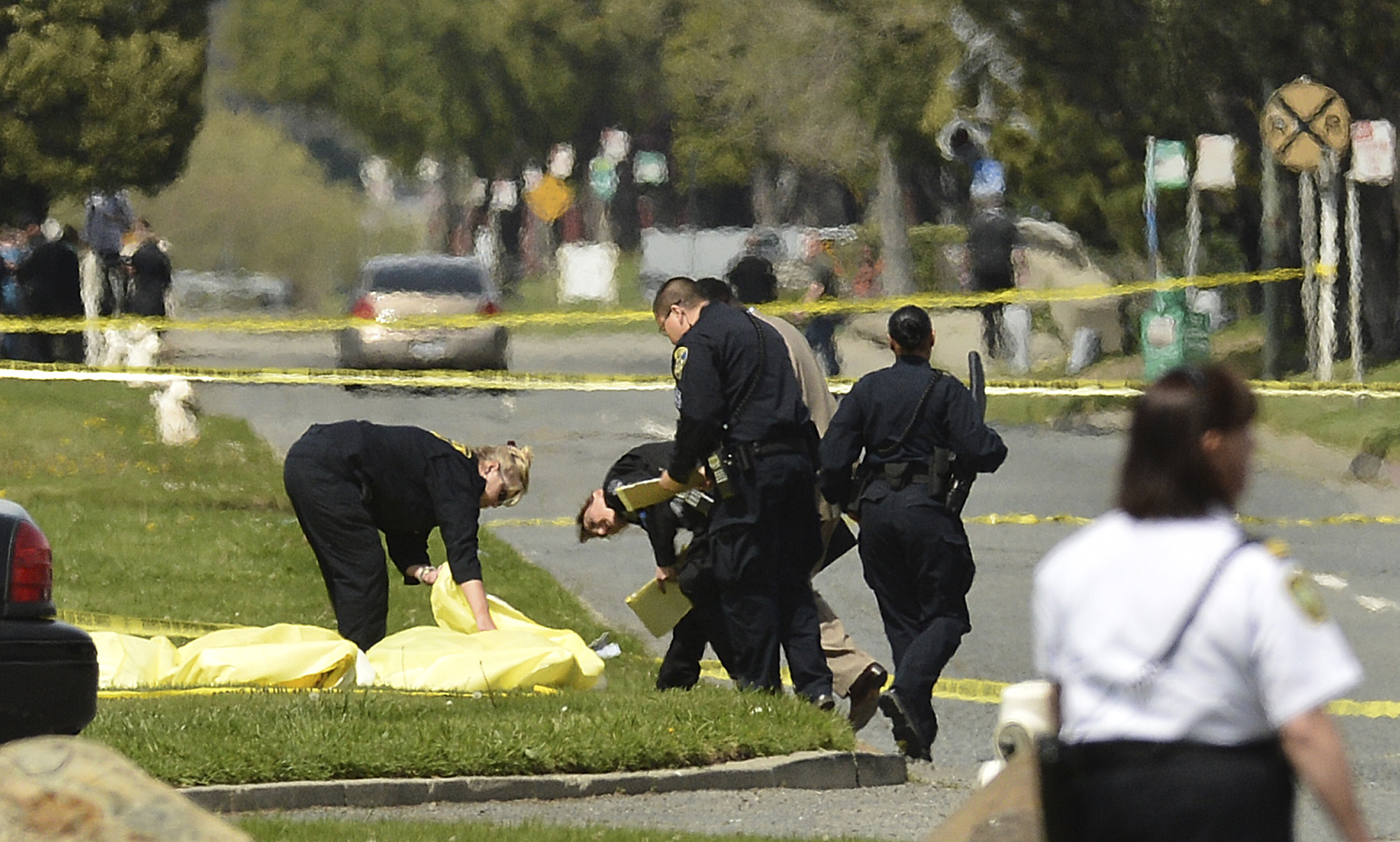 Polisen täcker över offrens kroppar utanför Oiko University i Kalifornien.