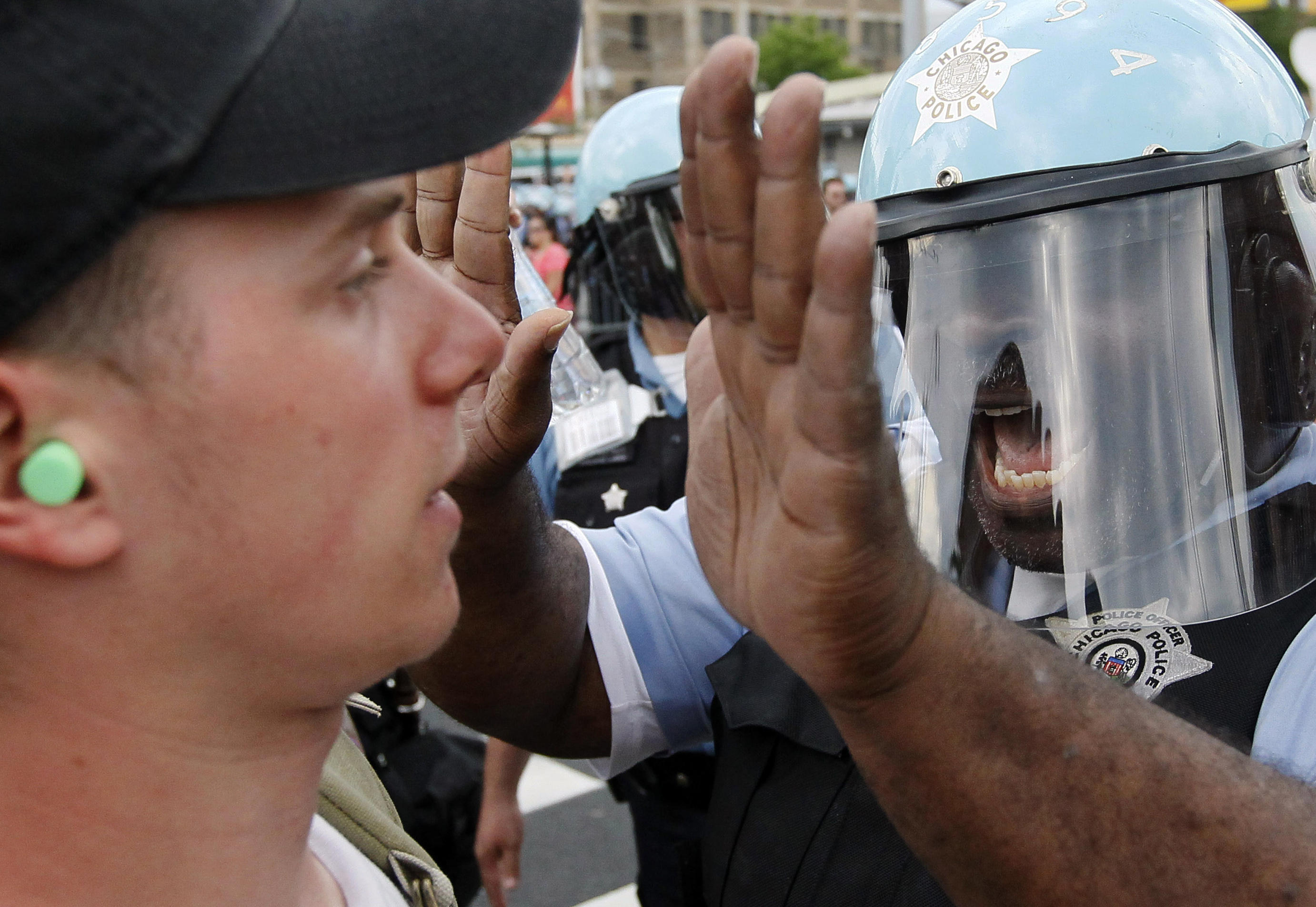 Polisen ger kalla handen till en ung man i demonstrationståget. 