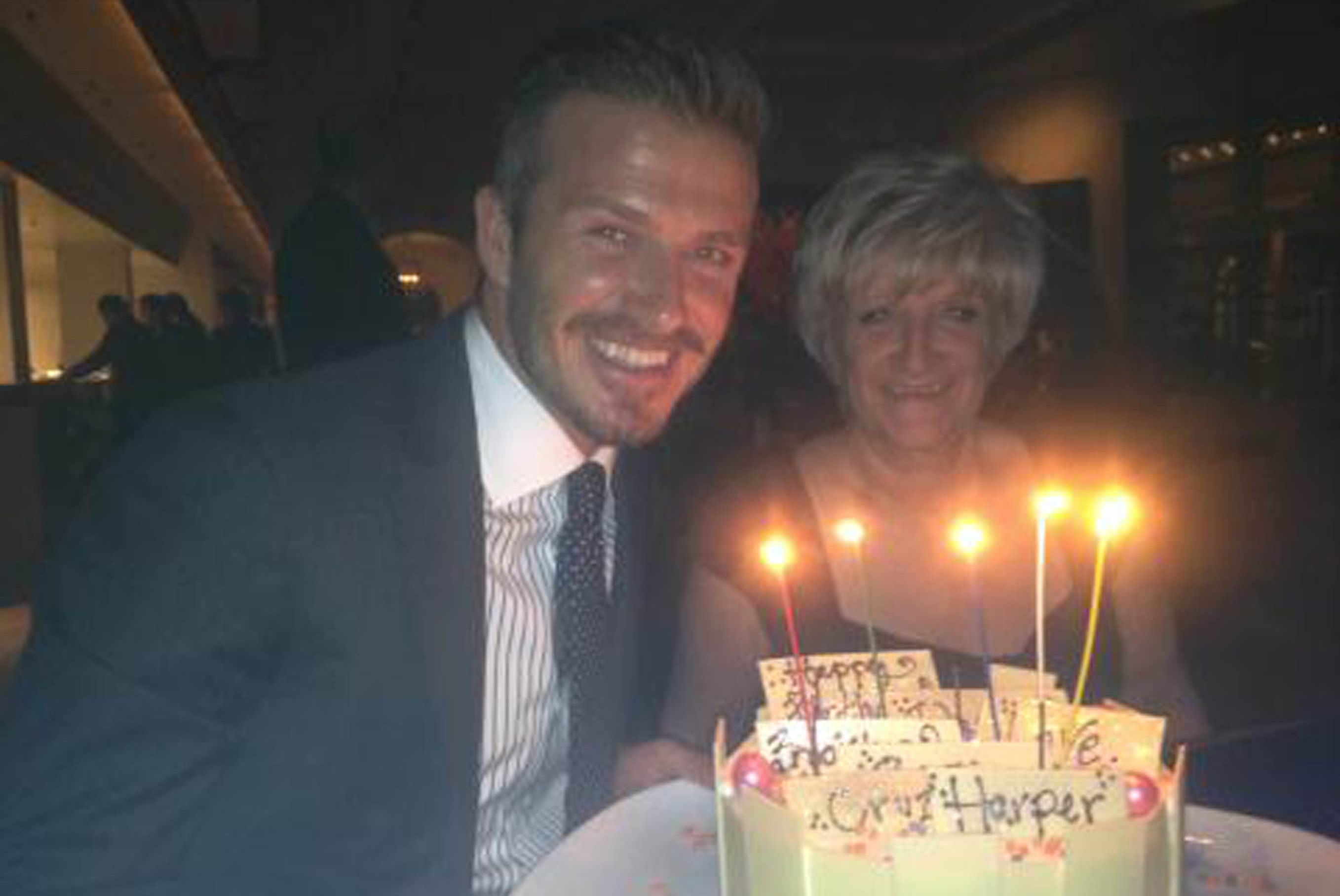 David Beckham fick en stor tårta och firades ordentligt av Victoria och mamma som sitter bredvid. 