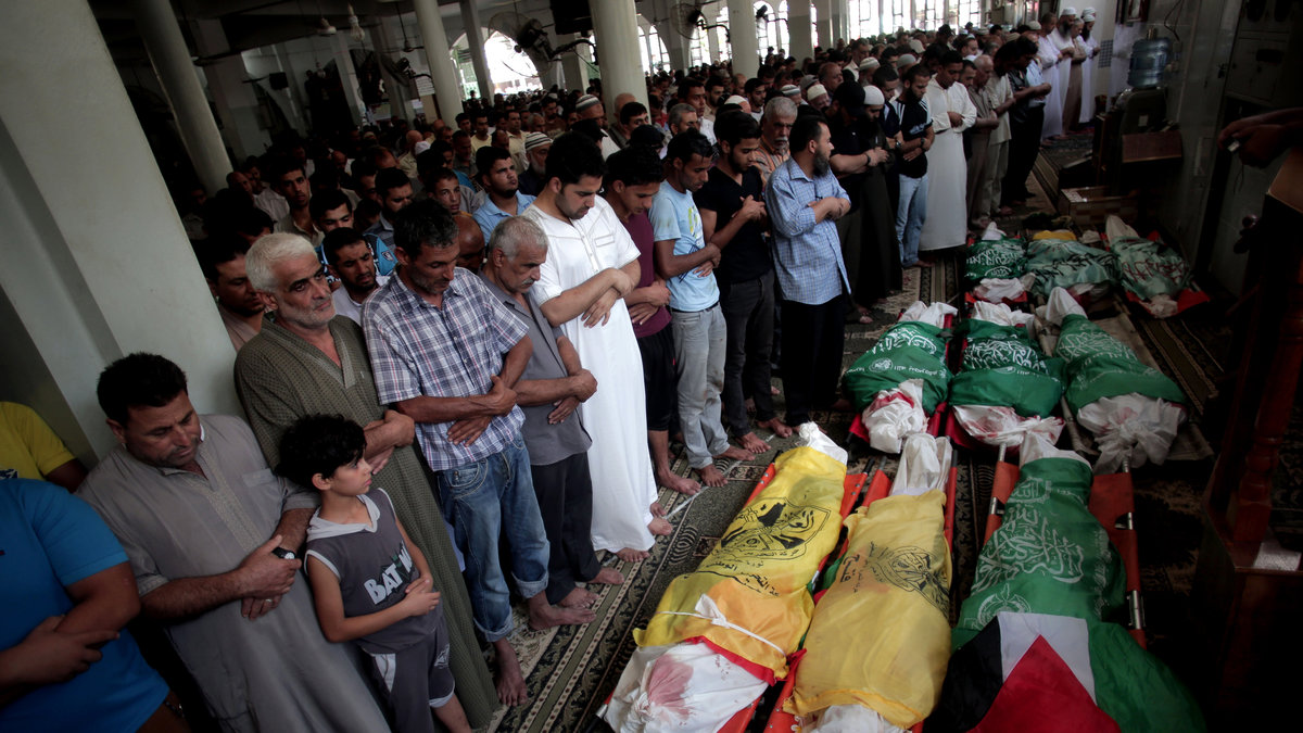 Människor ber för nio barn som omkommit efter israeliska bombningar. 