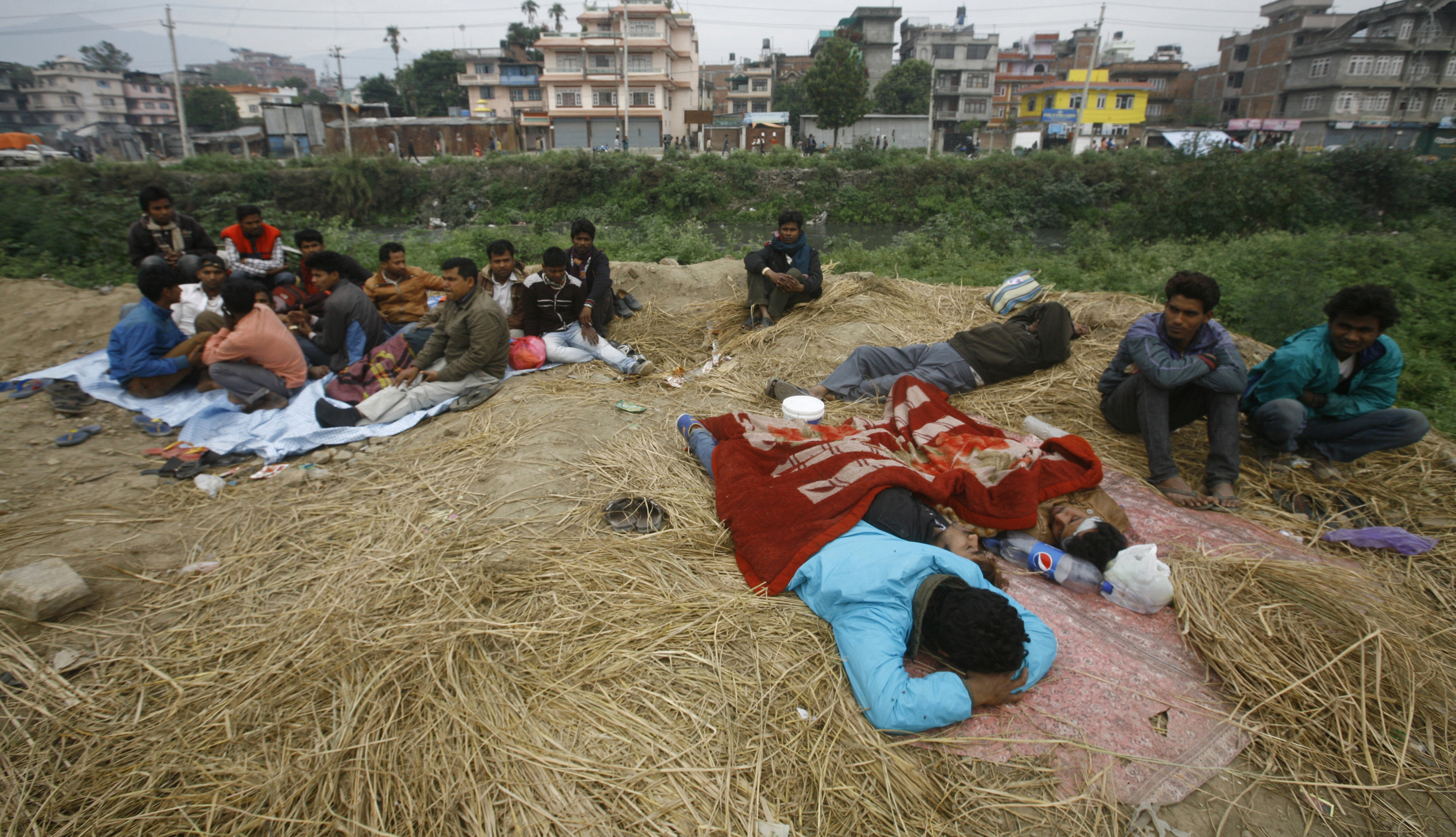 Folk vilar utomhus, dagen efter den massiva jordbävningen som ödelade regionen och förstörde mångas hem i Kathmandu.
