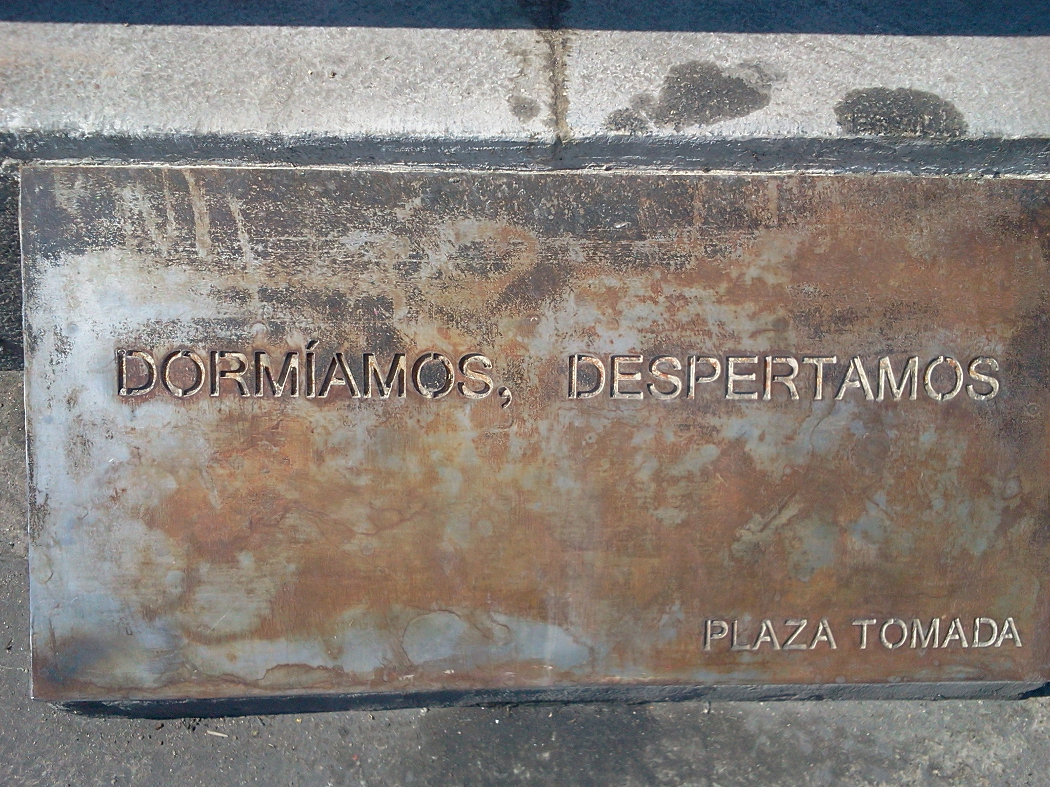 Plaketten som lämnades på platsen för 15-M-rörelsens start, torget Puerta del Sol i Madrid. Texten
lyder ”Vi sov, vi vaknar. Torget är taget”.
