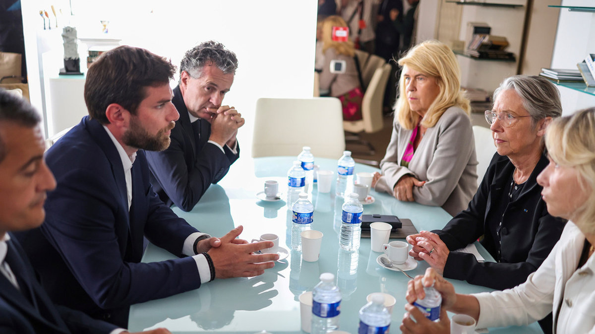 Frankrikes premiärminister Élisabeth Borne, på bordets högra sida i mitten, träffar borgmästare Vincent Jeanbrun, mittemot Borne, efter att en bil kört in i hans hem natten till söndag.