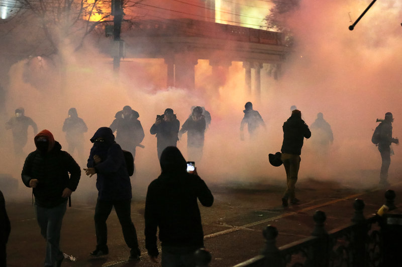 Demonstranter rör sig genom ett moln av tårgas i centrala Tbilisi under natten mot tisdagen.