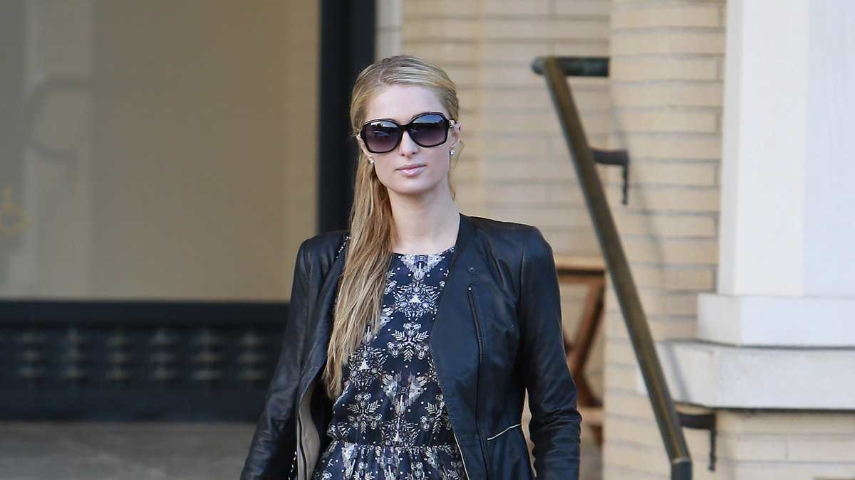 Skinjackor finna i olika modeller och kan bäras till det mesta. Paris Hilton har valt svart skinjacka till sin mönstrade klänning. 