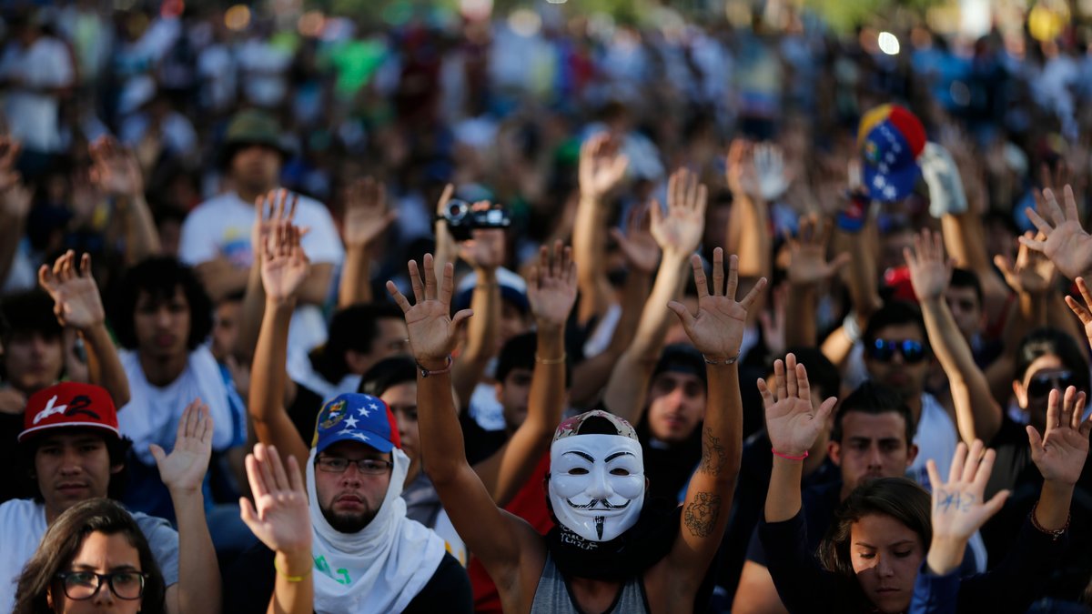Demonstranterna sträcker upp sina händer i en tyst protest för dödsoffren.