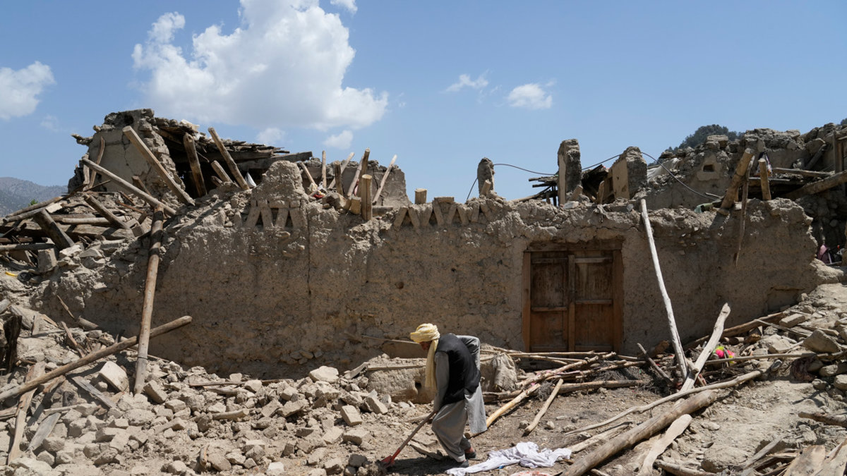 En man i provinsen Paktika röjer upp efter jordbävningen.