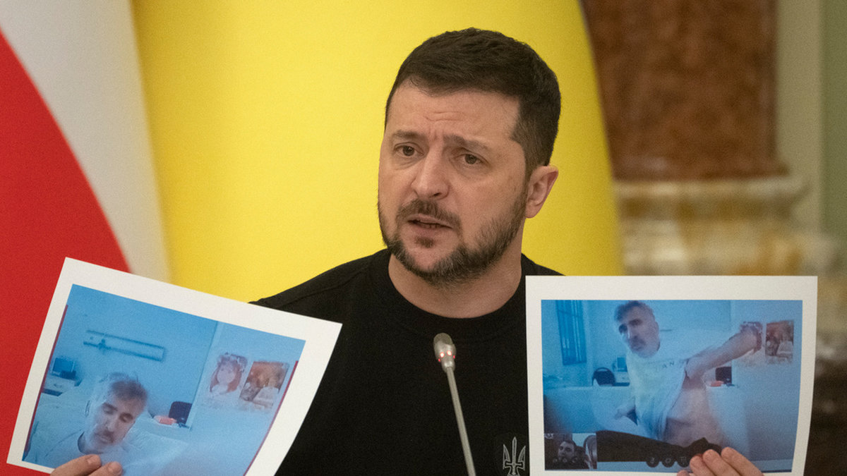 Ukrainas president Volodymyr Zelenskyj håller upp bilder på Georgiens fängslade ex-president Mikheil Saakashvili vid en pressträff i onsdags.