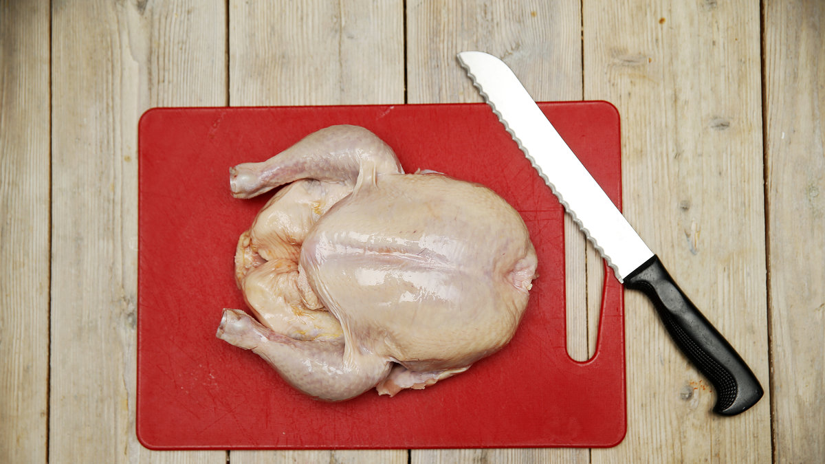 Rå kyckling på skärbräda